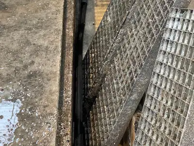 Curage d'un caniveau à grille avec tuyau haute pression